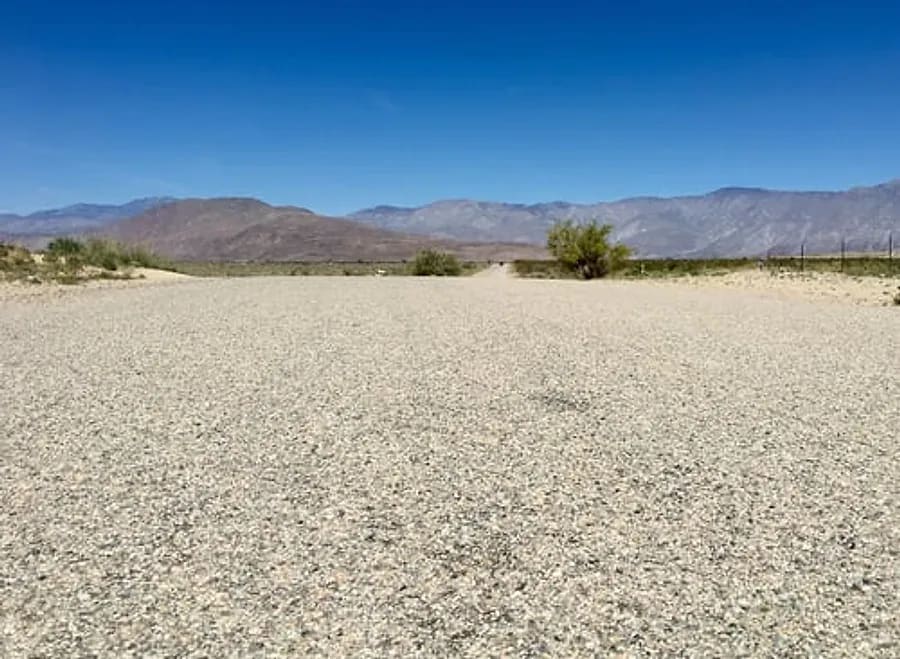 Freshly graded decorative gravel surface with Arizona desert mountains in the background